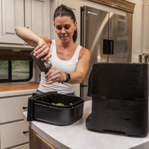 Woman cooking with an air fryer while boondocking in her RV