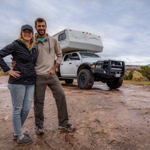 Tom and Caitlin Morton standing in front of their truck camper