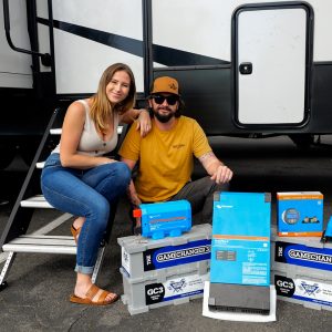 Taylor and Kiki with Battle Born Batteries in front of their Alliance Vallor Fifth Wheel RV