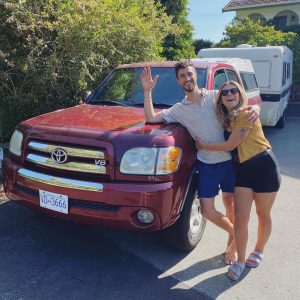 Levi Hildebrand and wife Leah in front of their trailer