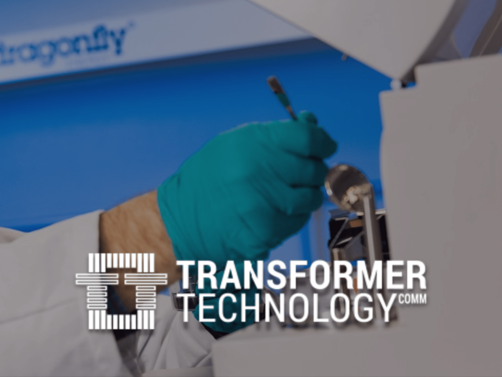 Transformer Technology Logo Over R7D Scientist Working in the Lab